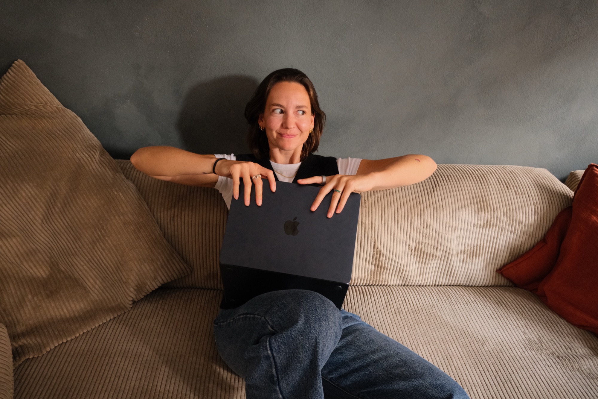 Fiona Raikes peeking over her laptop with a playful, knowing look